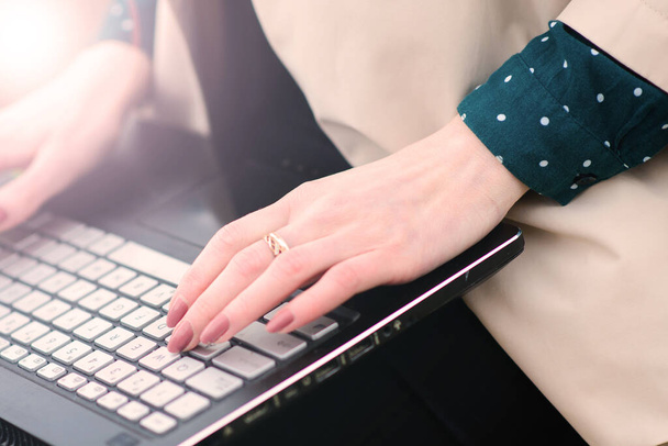 Γυναίκα που εργάζεται στο γραφείο στο σπίτι και σε εξωτερικούς χώρους, χέρι στο πληκτρολόγιο κοντά, laptop - Φωτογραφία, εικόνα