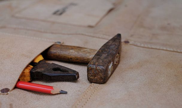 Collection d'outils à main de travail du bois en tablier de cuir sur établi rugueux en bois - Photo, image