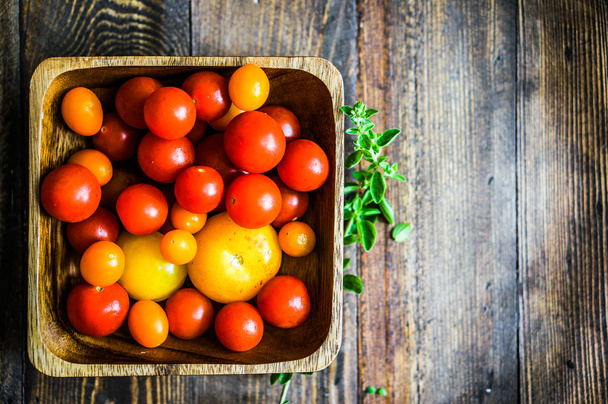 Colorful tomatoes on rustic background - Fotoğraf, Görsel