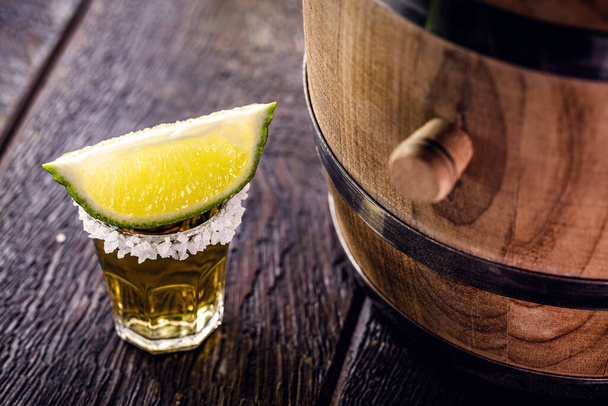 zlatá tequila s citrónem vedle dubového sudu, mexický nápoj - Fotografie, Obrázek