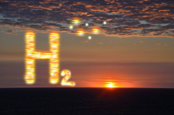 сияющие буквы h2 водорода с закатом и горящими облаками у моря - Фото, изображение