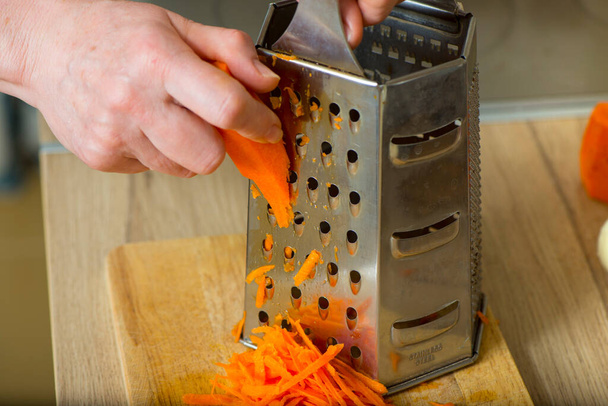 Cook grate carrots on a grater - Foto, immagini