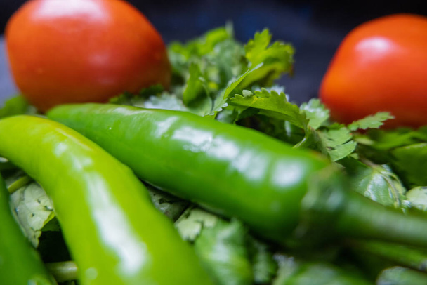Close-up de pimentas e tomates acima do coentro - Foto, Imagem