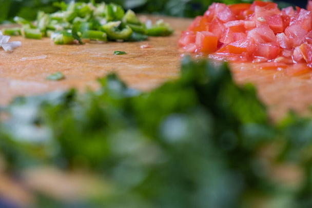Κοντινό πλάνο ψιλοκομμένο κόλιανδρο, ντομάτα και καυτερή πιπεριά - Φωτογραφία, εικόνα