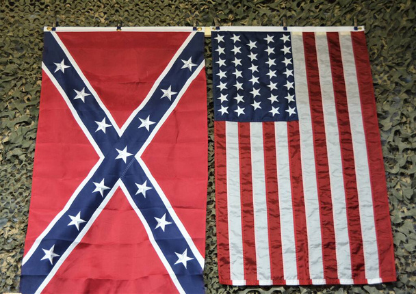 Amerykańska flaga i flaga konfederatów są uważane za rasistowskie według liberalnych demokratów po lewej stronie..  - Zdjęcie, obraz