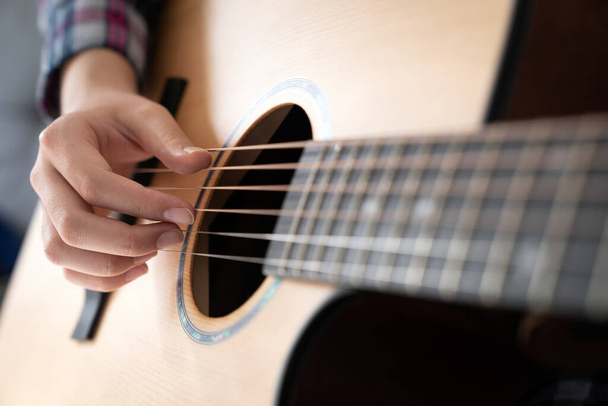 Női kezek akusztikus gitáron, közelről - Fotó, kép