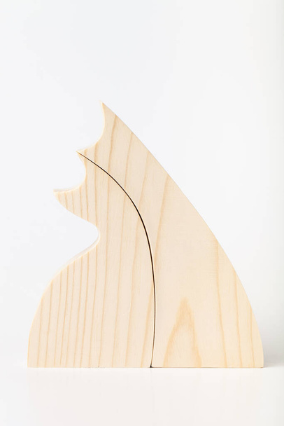 Figurine of embracing cats, carved from solid pine by hand jigsaw. On a white background . - Foto, afbeelding