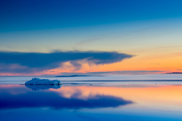 Тане айсберг на весняному гірському озері на заході сонця
. - Фото, зображення