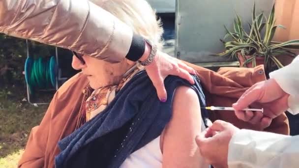 Donna anziana negli anni '90 vaccinata per pandemia covid-19 all'aperto - Filmati, video