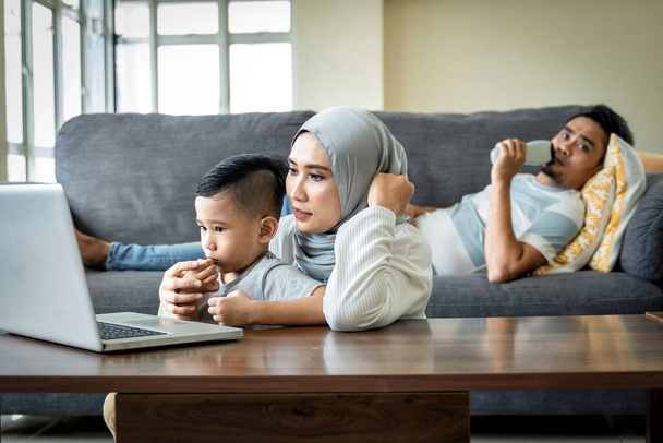 Inicio Concepto de escolarización, madre joven usando el ordenador portátil con su hijo en su regazo - Foto, imagen
