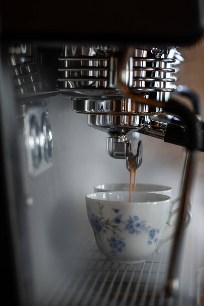 コーヒーマシンでエスプレッソを準備するプロセス。蒸気と美しいカントリースタイルのカップ - 写真・画像