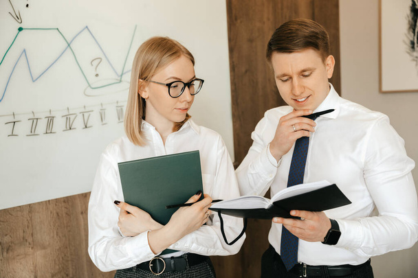 Business meeting and teamwork of business people in the office. Planning and designing a business plan as a team. Man and woman businessmen use notepads with documents.  - 写真・画像