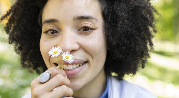 mixed afro woman, with daisies, in the park spring concept - Fotó, kép