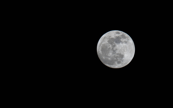 Полная луна над черным небом ночью. - Фото, изображение