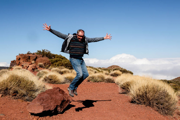 Heureux touriste en pleine croissance dans un saut. Le voyageur saute de joie, faisant un geste de victoire. L'homme est venu se reposer à Tenerife. - Photo, image