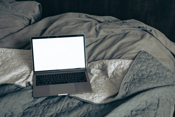 laptop na posteli s bílou obrazovkou kopírovací prostor - Fotografie, Obrázek