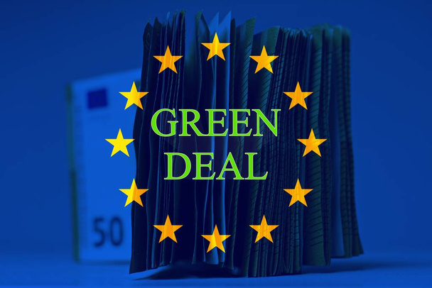 Mucchio di cinquanta euro sul tavolo, con bandiera europea e testo "green deal"" - Foto, immagini