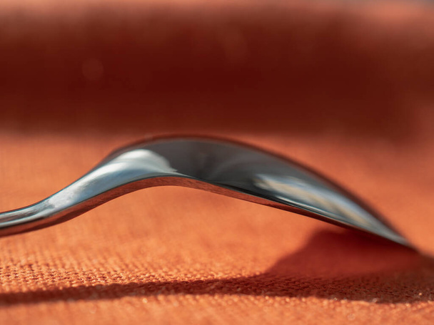 Steel spoon at the table-cloth macro - Fotografie, Obrázek