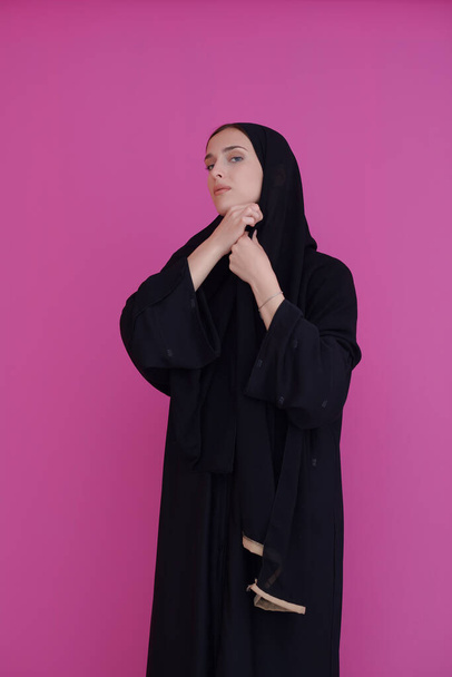 Modern young muslim woman in black abaya. Arab girl wearing traditional clothes and posing in front of black chalkboard. Representing modern and rich arabic lifestyle - Foto, imagen