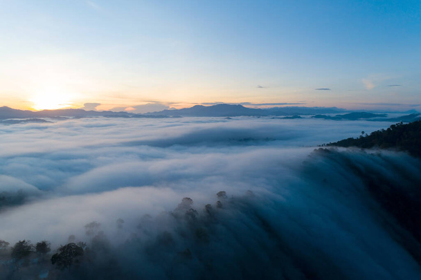 Increíble paisaje luz naturaleza paisaje vista, hermosa luz amanecer o atardecer sobre el mar tropical y niebla niebla en las montañas pico en Tailandia Vista aérea Drone cámara de tiro Vista de ángulo alto. - Foto, imagen