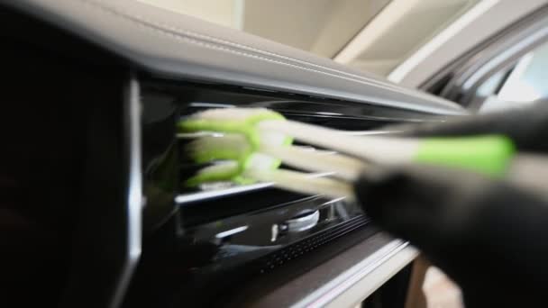 Brush cleaning off dust from the car interior details, ventilation deck. - Footage, Video