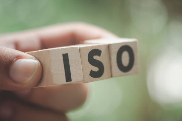 ISO ακρωνύμιο ή Διεθνής Οργανισμός Τυποποίησης σε ξύλινους κύβους στο χέρι. Επιλεκτική εστίαση - Φωτογραφία, εικόνα