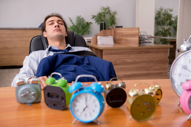 Jovem funcionário do sexo masculino dormindo no escritório em gestão de tempo co - Foto, Imagem