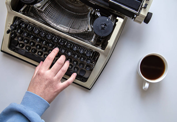 Kompozycja z maszyną do pisania, filiżanką kawy i odizolowaną dłonią kobiety. - Zdjęcie, obraz