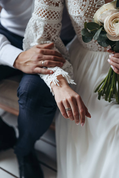 Primer plano de los anillos de boda en los dedos de la novia y el novio. Sesión de fotos de boda. - Foto, imagen