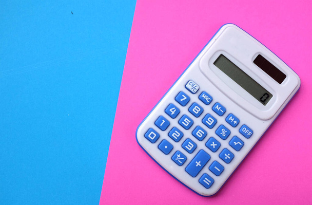 Una calculadora azul en el color de dos tonos fondo azul y rosa - Foto, imagen