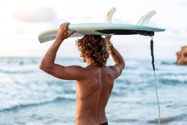 Jovem caucasiano levantar cedo para fazer surf ao nascer do sol - Foto, Imagem