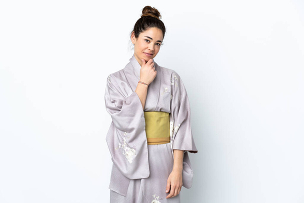 Donna che indossa kimono su sfondo isolato guardando di lato e sorridendo - Foto, immagini