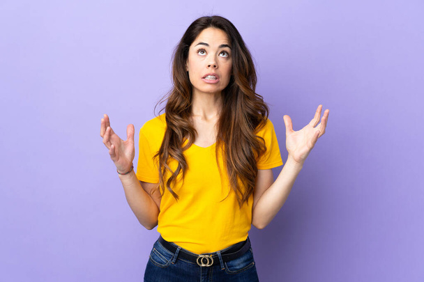 Woman over isolated purple background stressed overwhelmed - Foto, Imagen