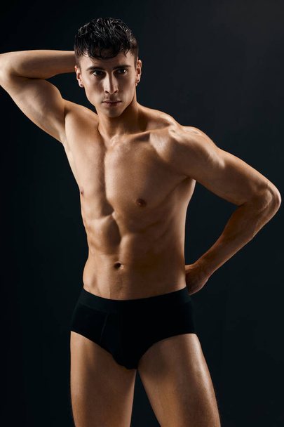 pohledný muž s svalnatým nahý tělo v tmavé kalhotky oříznuté pohled studio - Fotografie, Obrázek