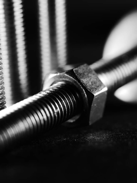 A close up studio shot of screws on black background - Foto, imagen