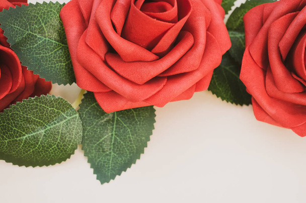 Τεχνητά κόκκινα τριαντάφυλλα που απομονώνονται στο φως φόντο - Φωτογραφία, εικόνα