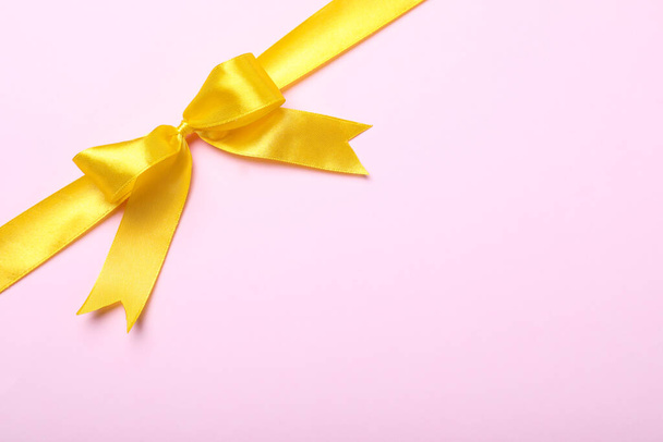 Yellow ribbon on pink background, top view. Space for text - Fotoğraf, Görsel