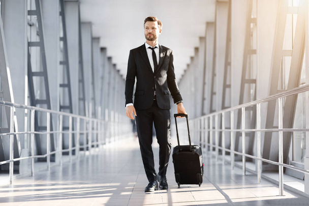 Empreendedor rico passando pelo aeroporto moderno, partindo para viagem de negócios - Foto, Imagem