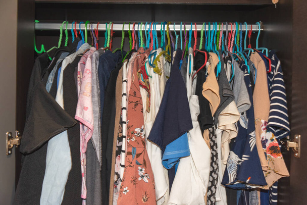 Otthoni szekrény sok női ruhával Akaszd fel a vállfára a szekrényben. Szűk ruha koncepció. - Fotó, kép