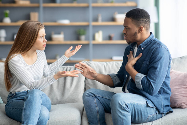 Problemas de parejas interraciales. Millennial hombre negro y mujer blanca discutiendo en casa - Foto, imagen
