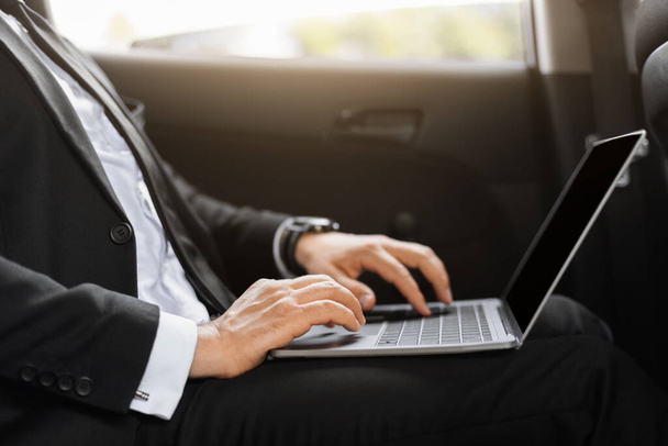 Businessman working on laptop while going to airport - Foto, Bild