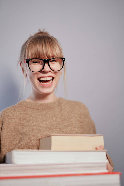 Gelukkig lachende nerd studente meisje met stapel boeken - Foto, afbeelding
