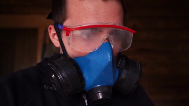 Ένας άντρας δουλεύει σε εσωτερικούς χώρους με γυαλιά και αναπνευστήρα.. - Πλάνα, βίντεο