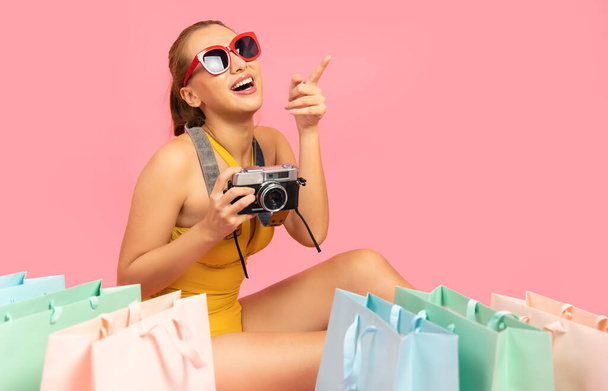Beautiful, Sexy asian woman in  bikini and smiling standing on pink background isolated .Summer vocation happy trip.She smiling and  happy shopping bags. - Foto, Imagen