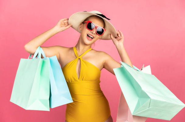 Beautiful, Sexy asian woman in  bikini and smiling standing on pink background isolated .Summer vocation happy trip.She smiling and  happy shopping bags. - Fotografie, Obrázek