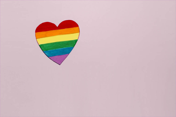 Szivárvány színű, kézzel készített szív rózsaszín háttérrel. Szimbóluma LMBTQ emberek és a hónap büszkeség koncepció - Fotó, kép