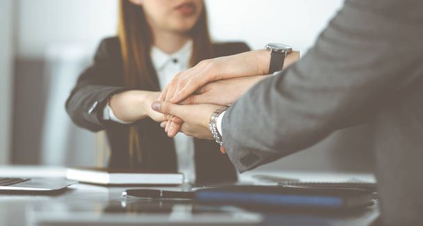 Unknown business people group joining hands in modern office. Businessmen and women making circle with their hands as a team, close-up - 写真・画像