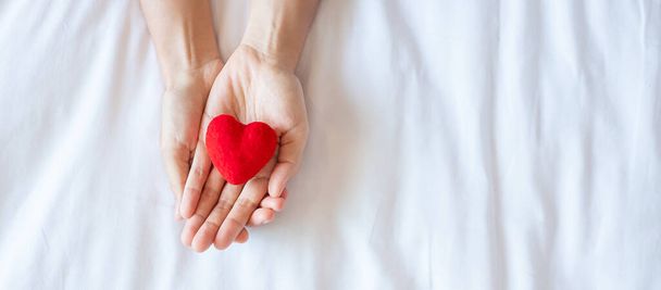 Mujer con forma de corazón rojo sobre fondo blanco. Salud, seguro de vida, donación, salud y concepto del Día Mundial del Corazón - Foto, imagen