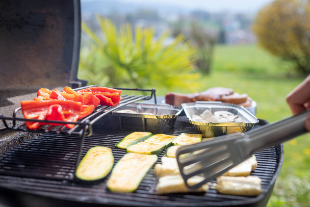 Close up of cheese and vegetables on gas grill. Summer time, outdoors. - Zdjęcie, obraz