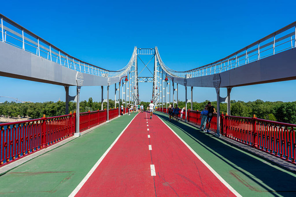 KYIV, UKRAJINA - 30.srpna 2020: Chodecký most přes řeku Dnypro v ukrajinském Kyjevě 30. srpna 2020.  - Fotografie, Obrázek